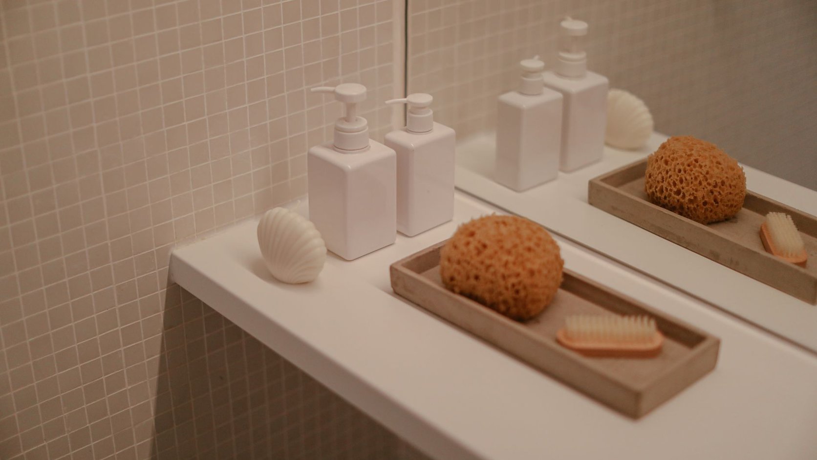 Lavabo claro com bandeja de apoio, frascos neutros e sensação de limpeza