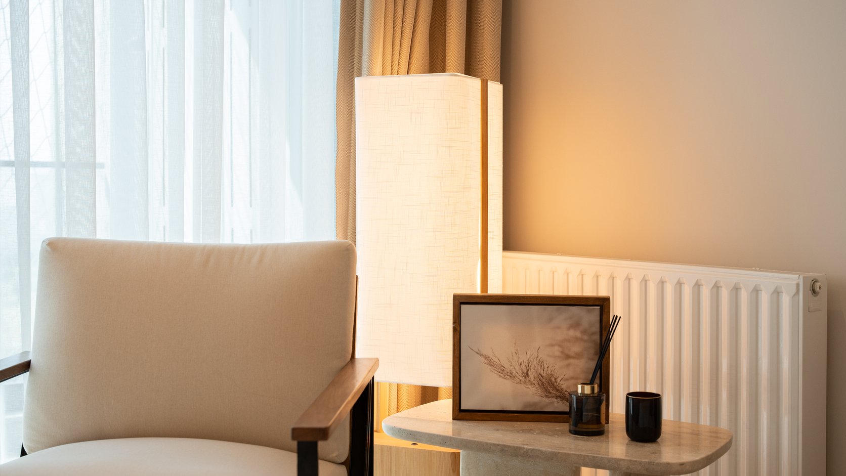 Mesa lateral com luz suave, difusor e texturas neutras compondo um clima sensorial