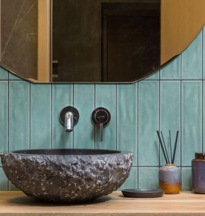 Lavabo cheiroso e decorado com difusor de varetas sobre bancada de madeira