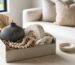 Caixa de presente com objetos de decoracao em composicao neutra e acolhedora