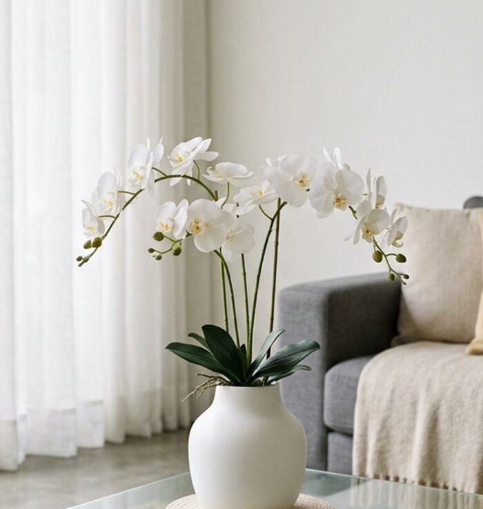 Arranjo elegante de orquídeas permanentes de silicone em um vaso moderno sobre a mesa